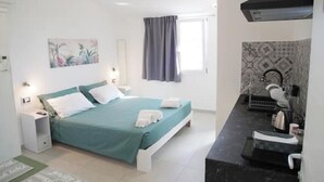 A bedroom with a bed, bedside table, and a window with curtains. - Sirocco - House of Jana (Quartu Sant'Elena)