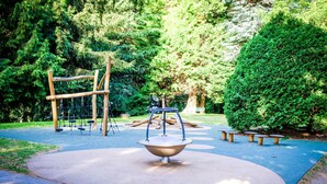 A playground with a seesaw, swings, and a climbing structure. - Villa Scurati (Brunate)