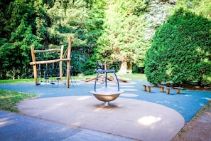 A playground with a seesaw, swings, and a climbing structure. - Villa Scurati (Brunate)