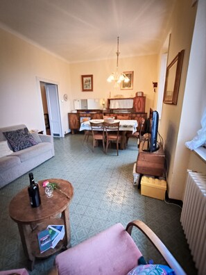 Un salon comprenant un canapé, une table basse et un coin repas avec des chaises et une table.