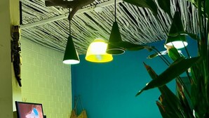 A reception desk with a computer monitor displaying a scenic image, a hanging bag, and a plant. - Pousada Toa Toa Maruda (Marapanim)