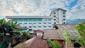 A multi-story hotel with a modern design, featuring a flat roof and large windows. - Paradise Hostel  (Vang Vieng)