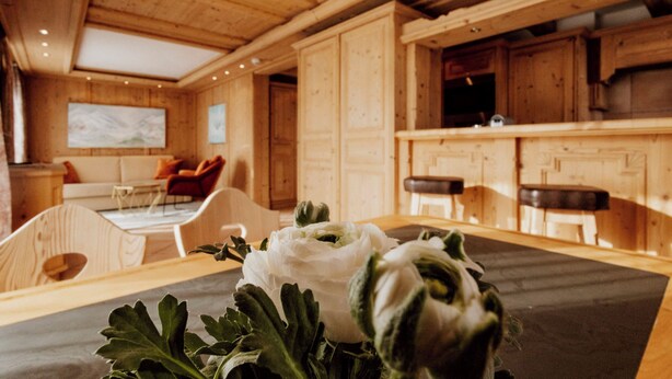 Een houten interieur met een eettafel, stoelen en een keukenhoek.