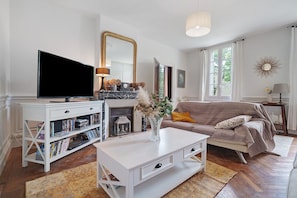A living room with a television, bookshelf, sofa, and fireplace.