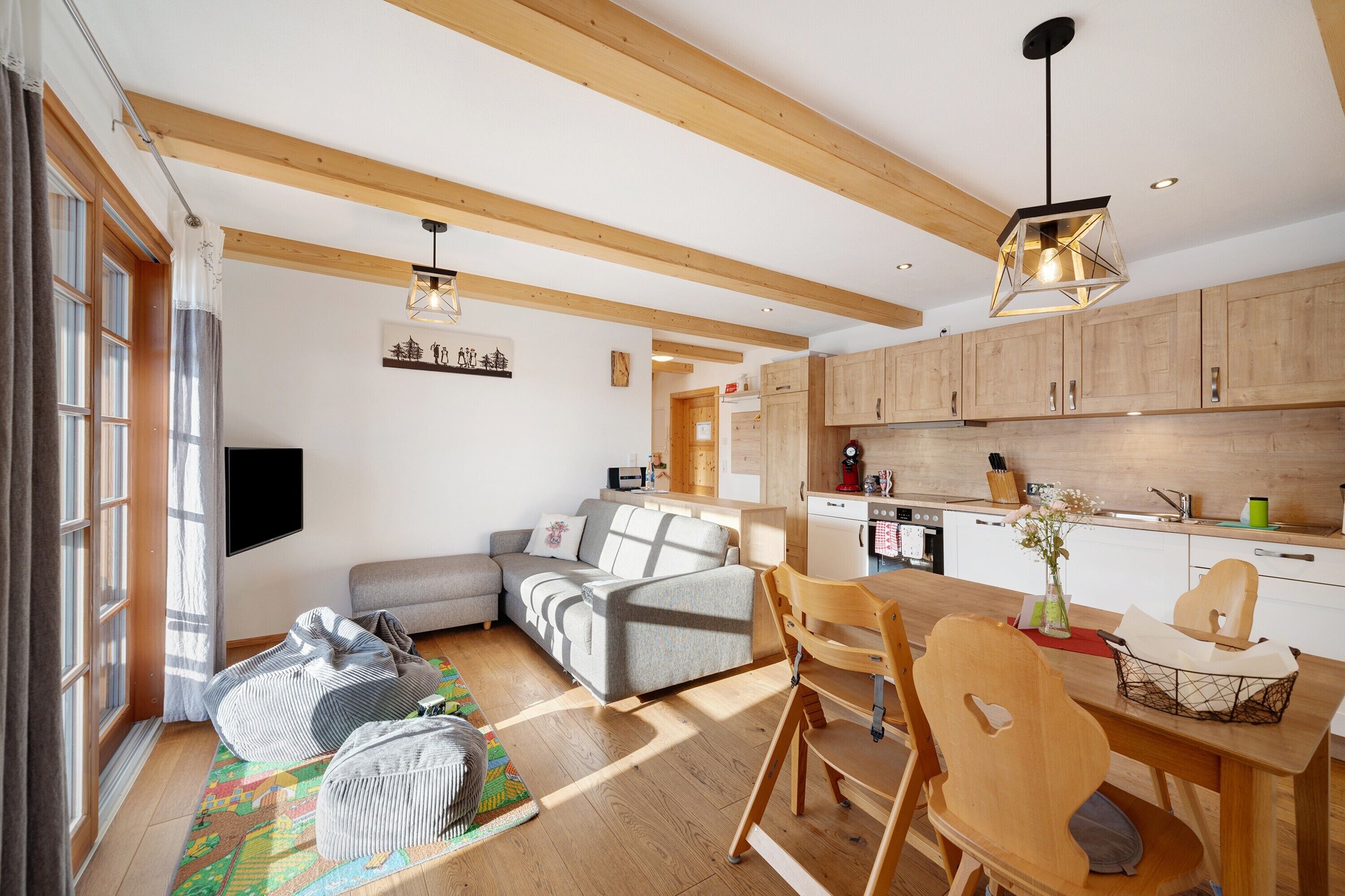 Eine moderne Küche mit Holzausstattung, einem Esstisch und einem eingebauten Backofen.