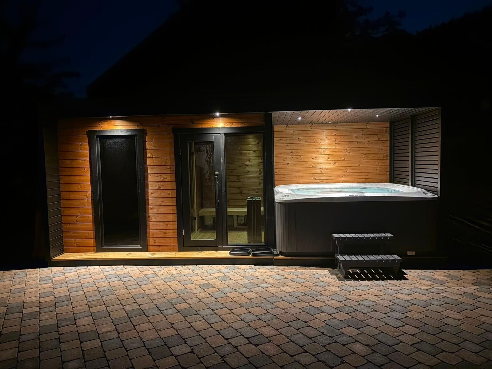 Een wellnessruimte met een jacuzzi, houten wanden en een betegelde vloer.