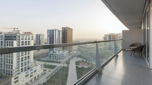 A modern apartment with a balcony, offering views of surrounding high-rise buildings and a construction site. - Stylish 2BR Business Bay Pool Access (Dubai)