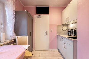 A compact kitchen with a refrigerator, a microwave, a coffee maker, and a sink. - Apartment 'Wencke' with Wi-Fi (Büsum)