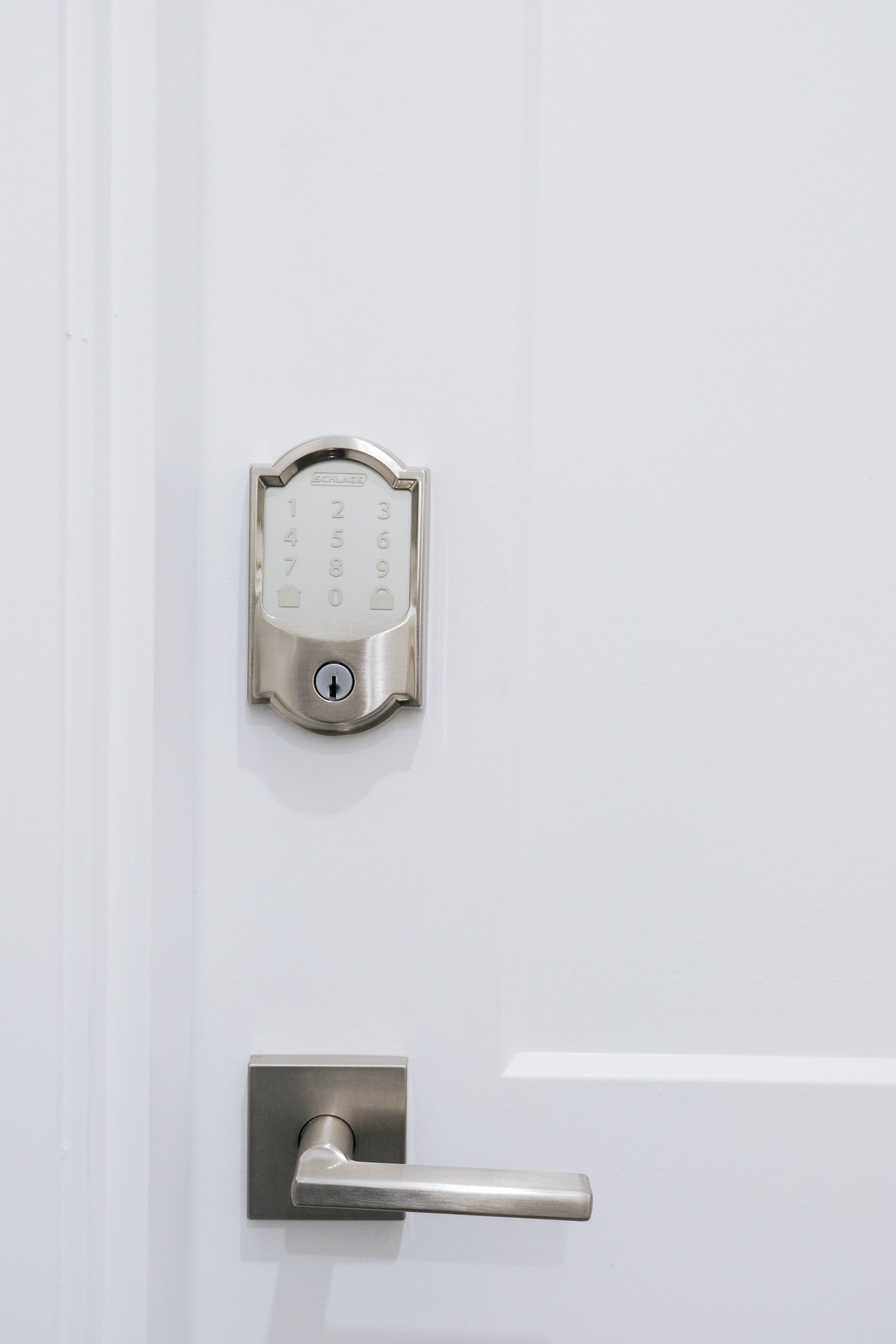 A modern door with a numeric keypad lock and a lever handle.