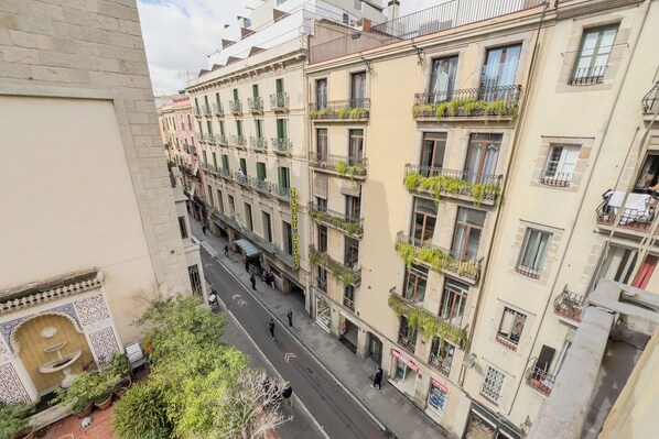 A multi-story building with balconies, a street in front, and a fountain in the courtyard. - STUDIO 4 NEAR THE RAMBLAS IN BARCELONA (Barcelona)