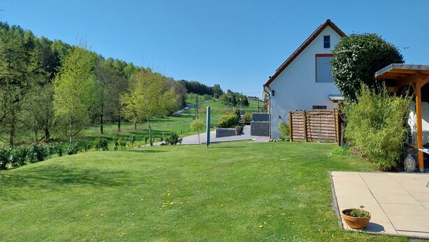A house with a garden, a wooden fence, and a paved area. - Holiday Apartment Ruhrort, 70 sqm with Private Terrace, Garden and Wi-Fi (Brilon)