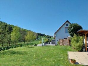 A house with a garden, a wooden fence, and a paved area. - Holiday Apartment 'Ferienwohnung Ruhrort' with Private Terrace, Garden and Wi-Fi (Brilon)
