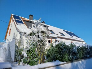 A house with a sloped roof, solar panels, and snow-covered surroundings. - Holiday Apartment 'Ferienwohnung Ruhrort' with Private Terrace, Garden and Wi-Fi (Brilon)