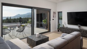 Un salon moderne avec un canapé, une table basse et un téléviseur.