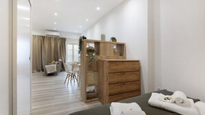 Une chambre à coucher avec un lit, une commode en bois, un bureau et une chaise.