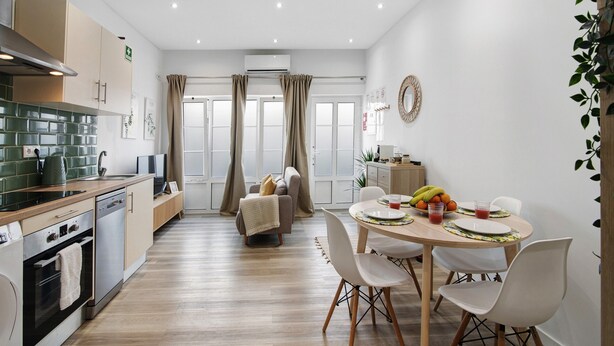 Une cuisine moderne avec un coin repas, un plancher en bois et une vue par la fenêtre.