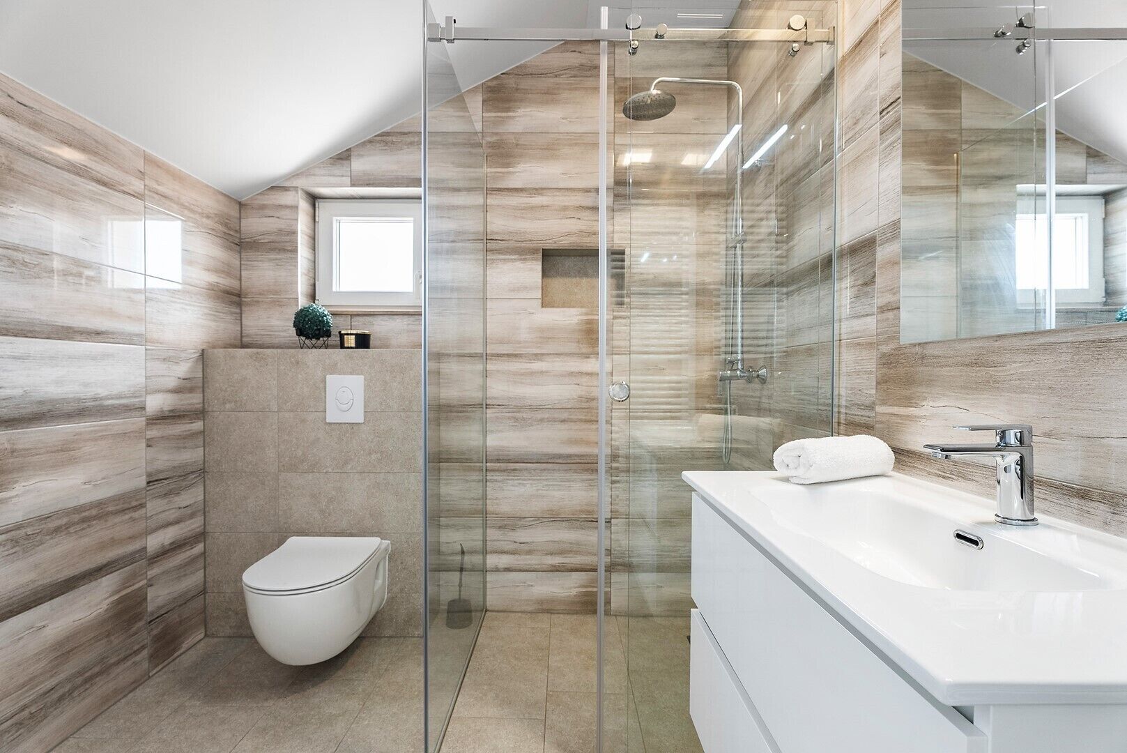 A modern bathroom with a glass-enclosed shower, a toilet, and a white vanity with a mirror.