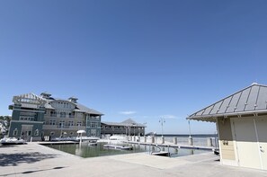Une propriété située au bord de l’eau, comprenant un grand bâtiment, une piscine et un petit pavillon.
