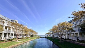 En kanal med byggnader på båda sidor, en klar himmel och en avlägsen vy över vattnet.