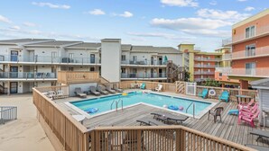 Ein Poolbereich mit Liegestühlen und einer Holzterrasse.