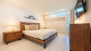 A bedroom with a bed, nightstands, a TV, and a wardrobe. - OASIS 2BR/2Bath STEPS from BEACH + Parking @ ESJ (Carolina)