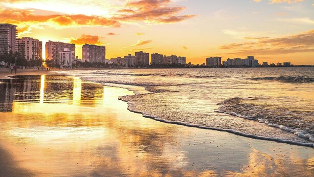 A beach with a city skyline in the background during sunset. - OASIS 2BR/2Bath STEPS from BEACH + Parking @ ESJ (Carolina)