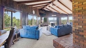 A spacious room with large windows, a fireplace, and a view of the outdoors. - Hiwassee Lake Lodge - Private Mtn-Top Retreat - Lake Views - Sleeps 13 (Murphy)
