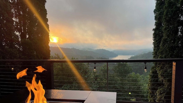 A fire feature with a view of a sunset over a lake and mountains. - Hiwassee Lake Lodge - Private Mtn-Top Retreat - Lake Views - Sleeps 13 (Murphy)