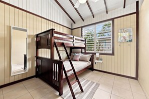 Ein Etagenbett mit einer Leiter, ein Fenster mit Jalousien und ein kleines Regal mit Gegenständen.