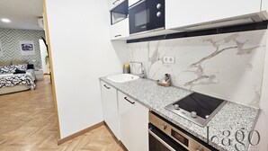 Une cuisine moderne avec des meubles blancs, un four à micro-ondes, un évier et une cuisinière.