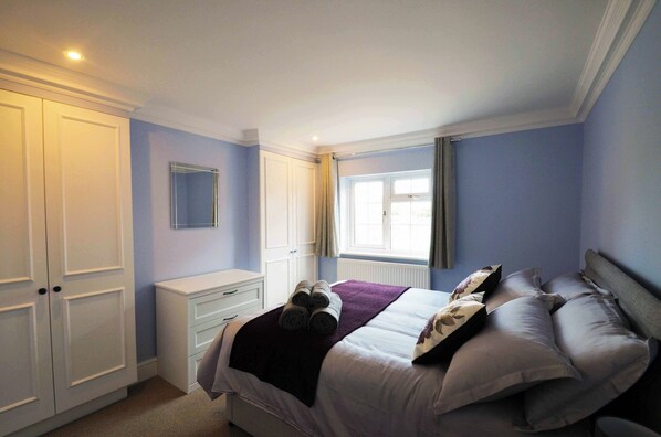 A bedroom with a bed, a nightstand, a wardrobe, and a window. - STABLE HOUSE - ETON WINDSOR (Eton)