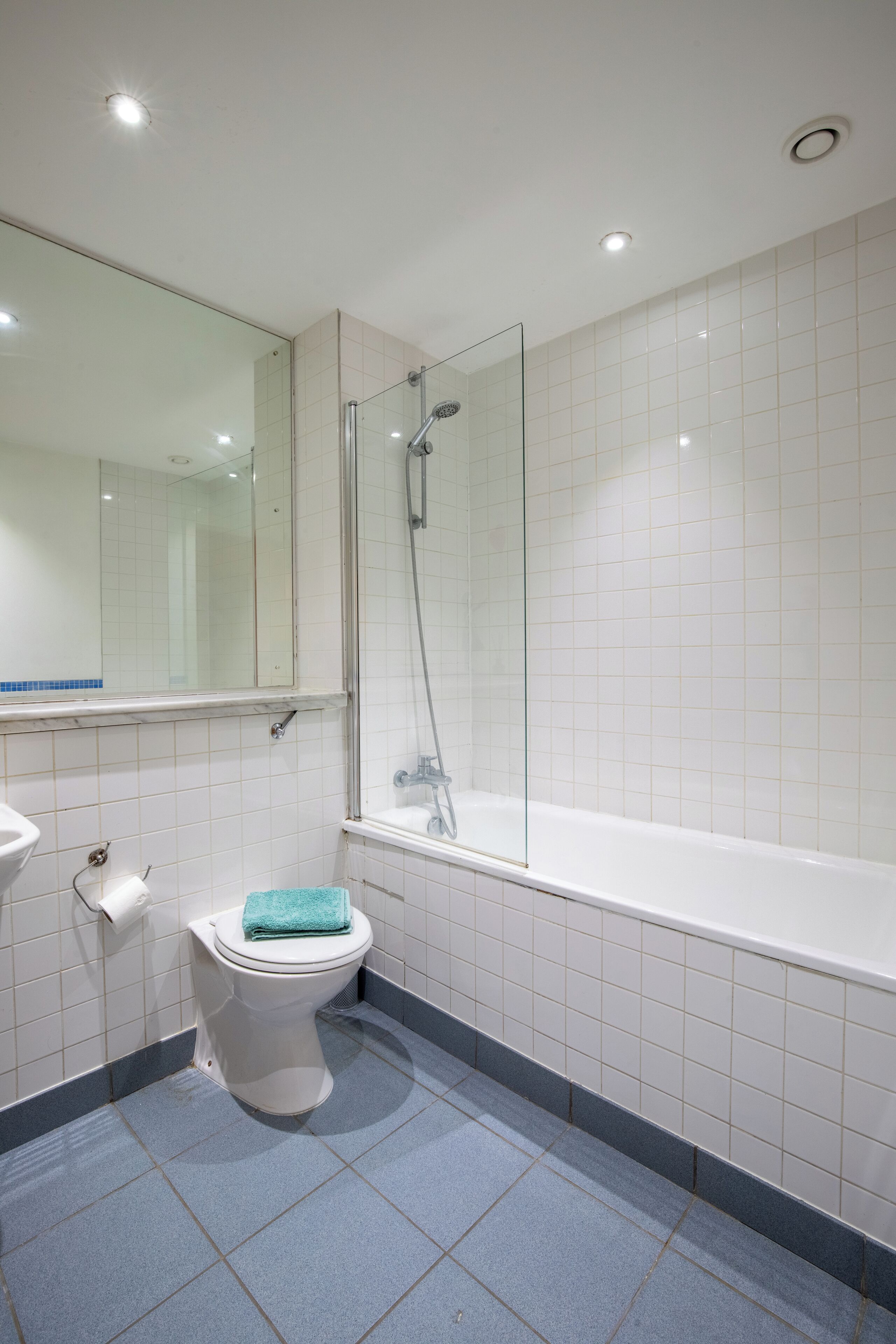 Een moderne badkamer met toilet, wastafel en douche.