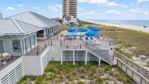 A beachfront hotel with a pool area, outdoor seating, and a view of the beach and ocean. - Gone Gulfing - Isle Be Chillin (Pensacola)