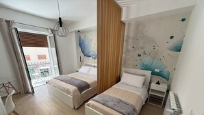 A modern bedroom with two beds, a balcony, and a decorative wall mural. - Bart165 Luxury Rooms (Palermo)