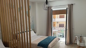 A modern hotel room with two beds, a balcony with a table and chairs, and a view of the cityscape. - Bart165 Luxury Rooms (Palermo)