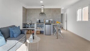 Eine moderne Küche mit Einbauofen, Kühlschrank und Essbereich mit Tisch und Stühlen.