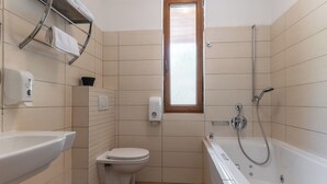 A bathroom with a toilet, sink, and bathtub. - Archa restaurant a hotel (Olomouc)