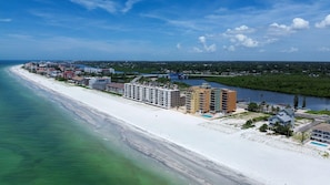 A coastal area with a long sandy beach, a marina, and several multi-story buildings. - Holiday Villas III #209 (Indian Shores)