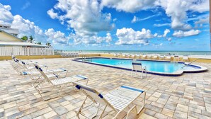 A pool area with lounge chairs and a view of the ocean. - Holiday Villas III #209 (Indian Shores)