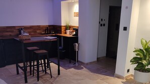 Uma sala de estar com um sofá e um espaço de jantar com mesa e cadeiras.
