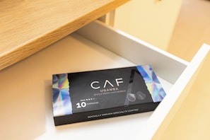 A box of CAF Uganda coffee capsules with a label indicating 10 capsules.