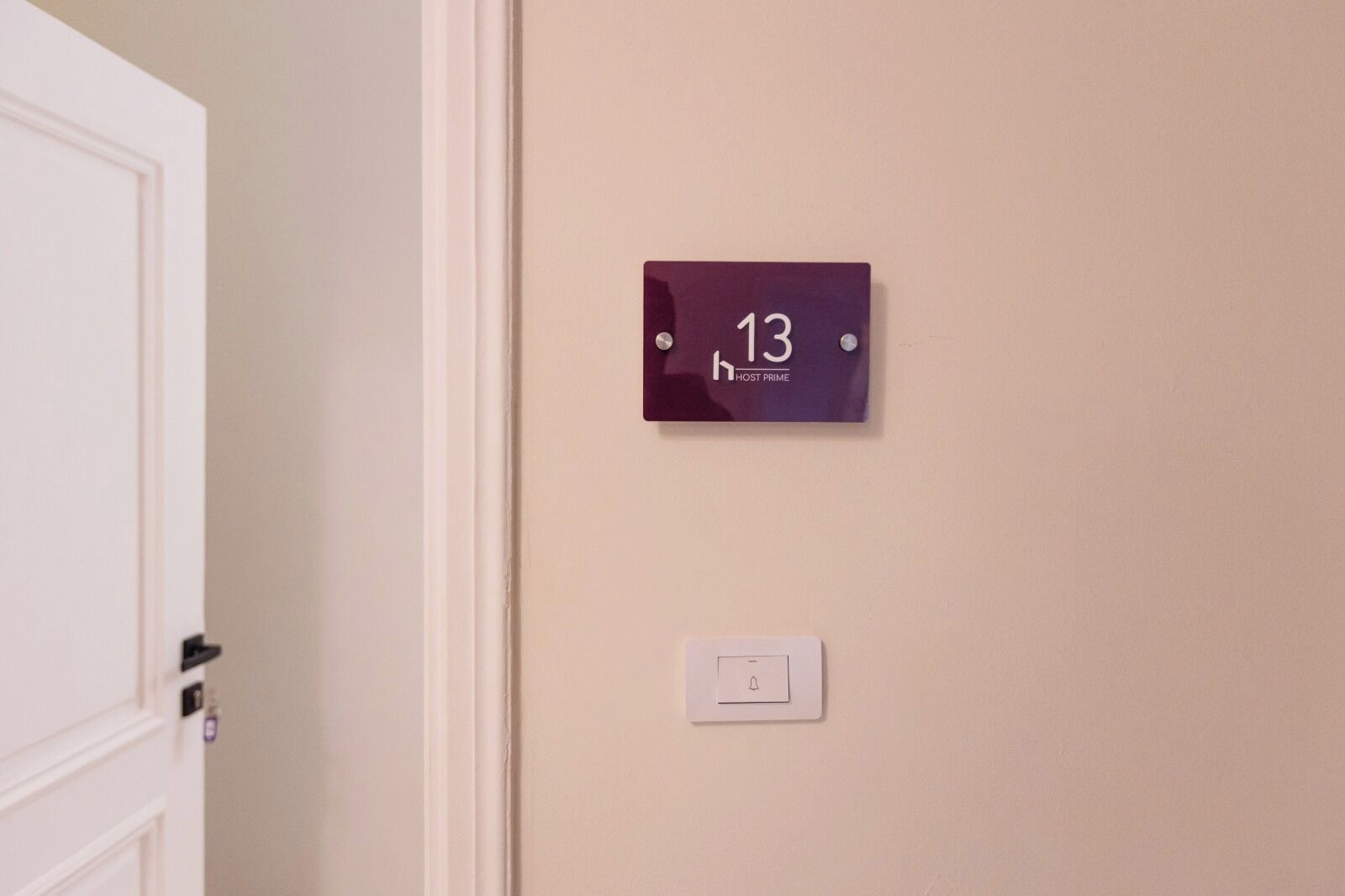 Una porta amb un quadre amb el número de l'habitació a dalt i un interruptor de llum a sota.