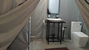Un bagno piccolo e chiuso con lavandino, specchio e water.