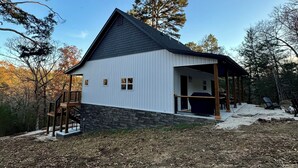 A modern house with a stone foundation, a wooden deck, and a covered porch. - Beautiful 2-Bedroom Getaway in Marble Falls: Hike, Float, Unwind in the Ozarks (Marble Falls)