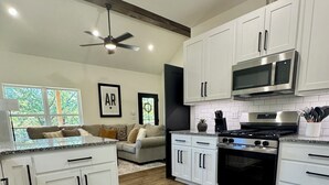 A modern kitchen with white cabinets, a stainless steel stove, and a microwave. - Beautiful 2-Bedroom Getaway in Marble Falls: Hike, Float, Unwind in the Ozarks (Marble Falls)