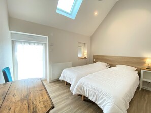 2 dormitorios y tabla de planchar con plancha