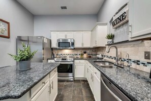 A modern kitchen with white cabinets, granite countertops, stainless steel appliances, and a backsplash with a mosaic tile pattern. - 3BD Home  Garage  HWY 360  Grand Prairie (GP020) (Grand Prairie)