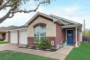 A single-story house with a brick facade, a large arched window, and a blue front door. - 3BD Home  Garage  HWY 360  Grand Prairie (GP020) (Grand Prairie)