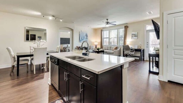A modern kitchen with dark cabinetry, a white countertop, and a built-in sink. - 3BD  Pool Table Dallas Dallas DAL212 (Dallas)