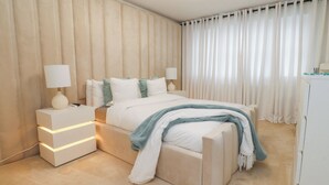 A modern bedroom with a large bed, bedside tables, and a nightstand. - Mellings Place (Carnforth)